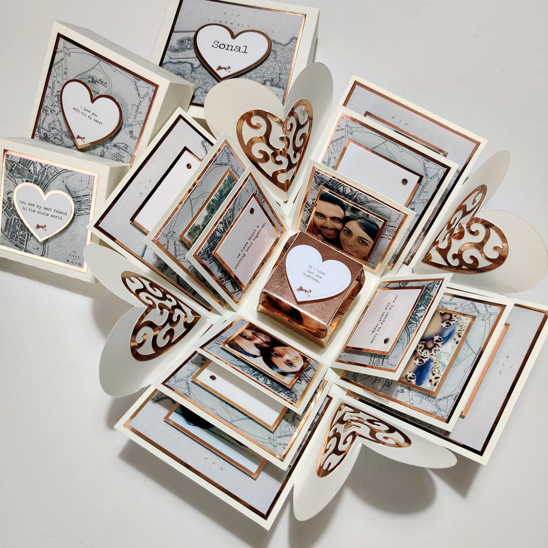 Heart-shaped box with a white heart and an assortment of photos, including a close-up of a woman's face and a picture of a man and woman.