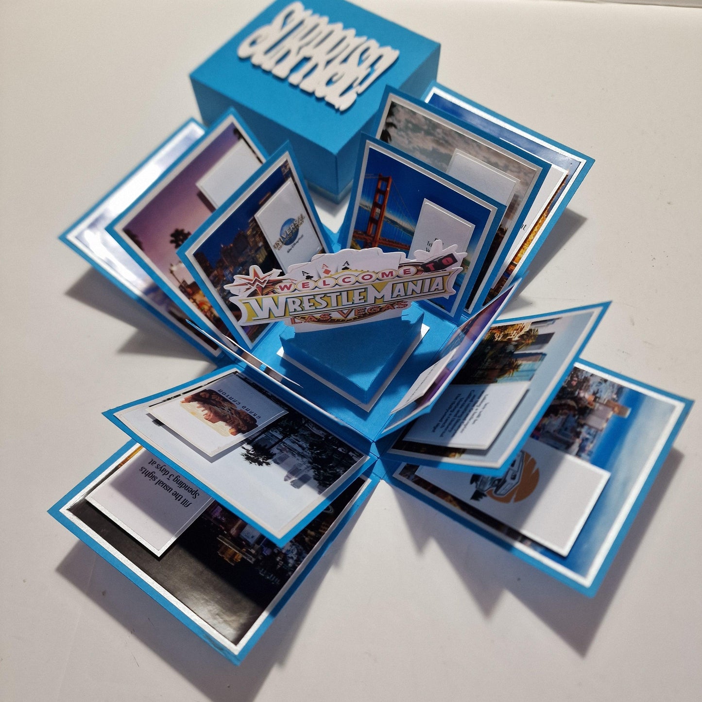 Exploding Occasions Box - Trip Reveal - Custom Occasion displayed open with visible photos and cards inside, highlighting its design for personalized gift-giving and special announcements.