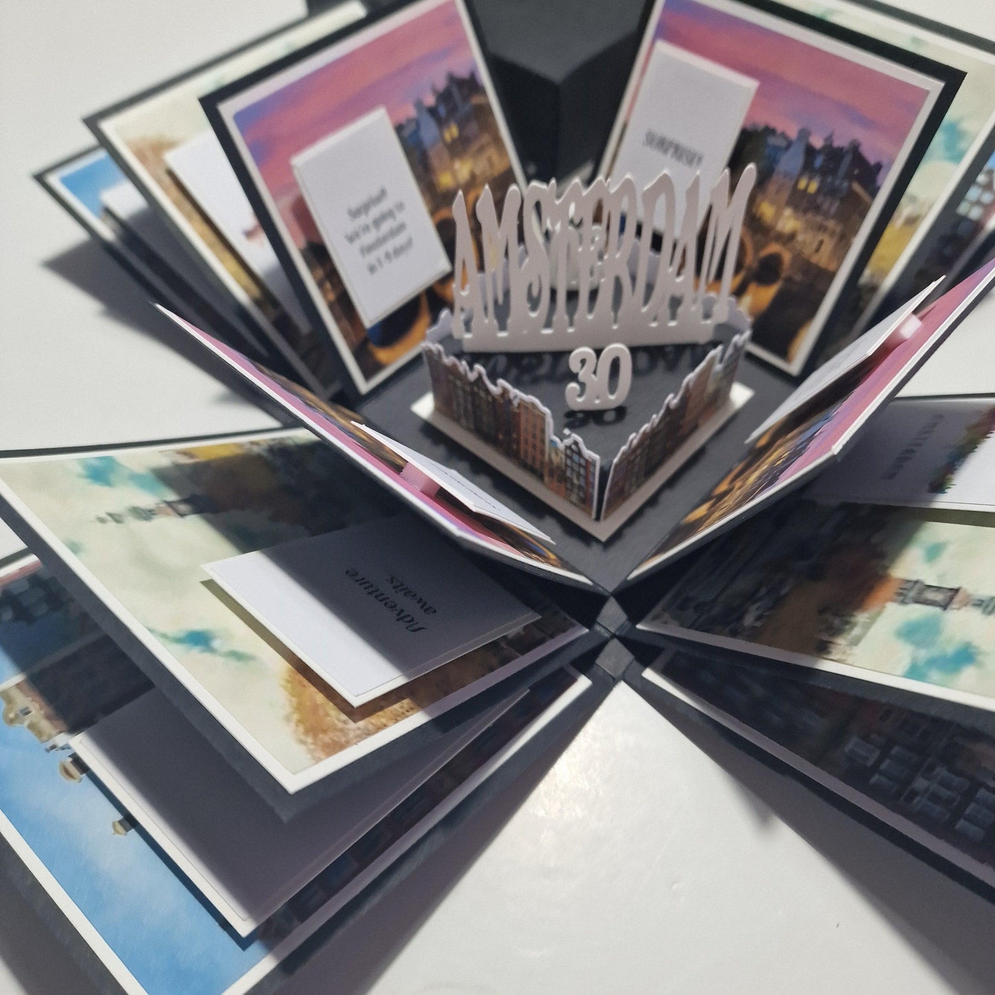 Exploding Occasions Box - Trip Reveal AMSTERDAM featuring a paper box with Amsterdam city images and themed panels, designed for a special surprise trip reveal with personalized details.