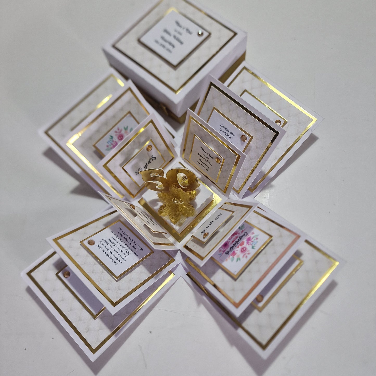 Golden Wedding Anniversary Exploding Box featuring a white and gold design with a gold figure inside, elegantly crafted to commemorate a 50th wedding anniversary.