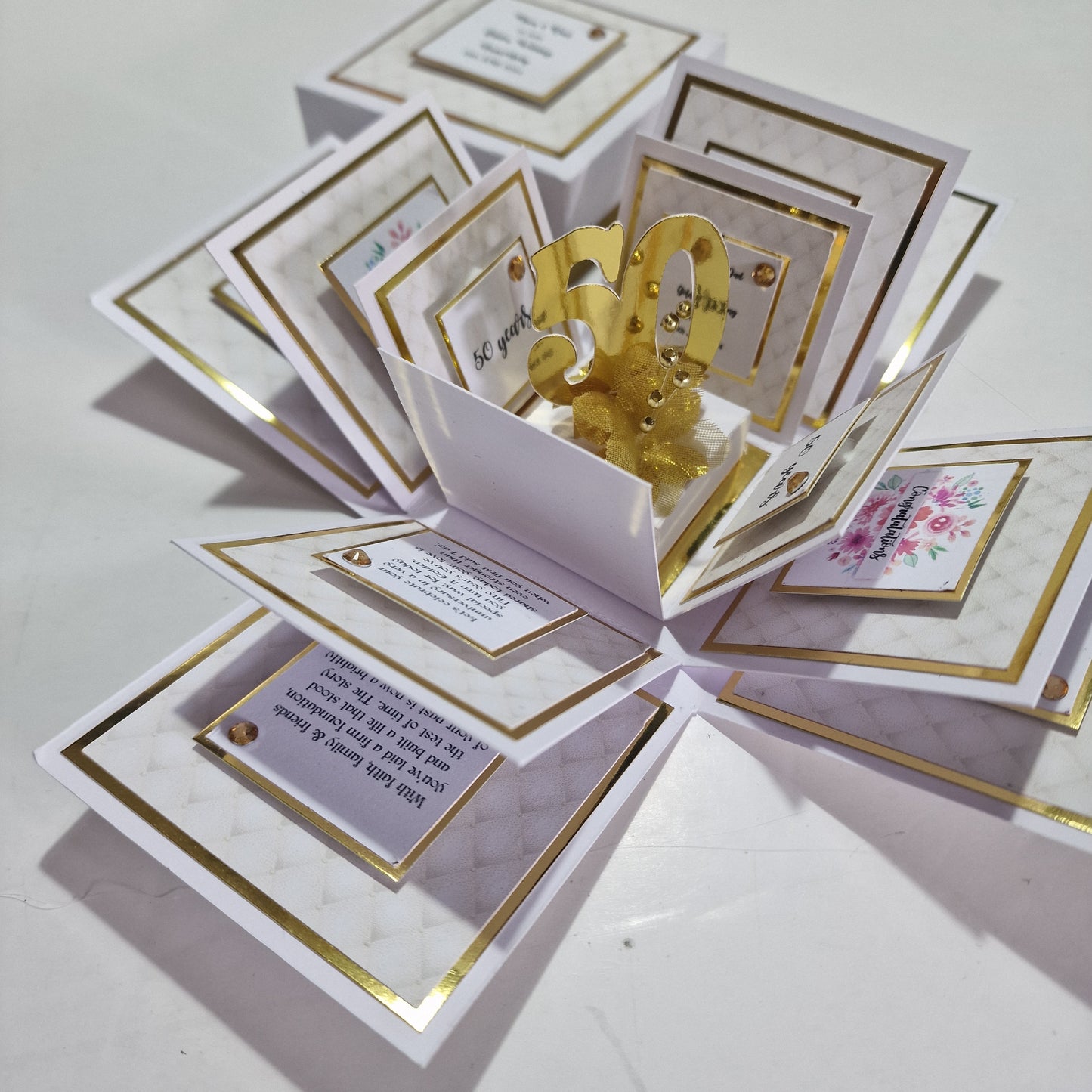 Golden Wedding Anniversary Exploding Box featuring a white and gold design with personalized elements, including names, dates, and messages, celebrating a 50th anniversary with elegance and heartfelt details.