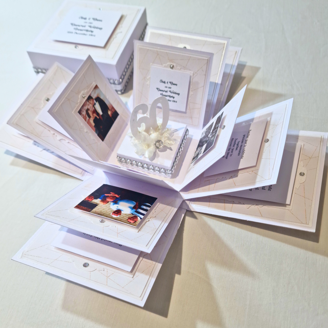 Diamond Wedding Anniversary Exploding Box featuring a white box adorned with photos and text, designed as a keepsake gift, with internal panels displaying occasion-appropriate messages and decorative Diamontes.