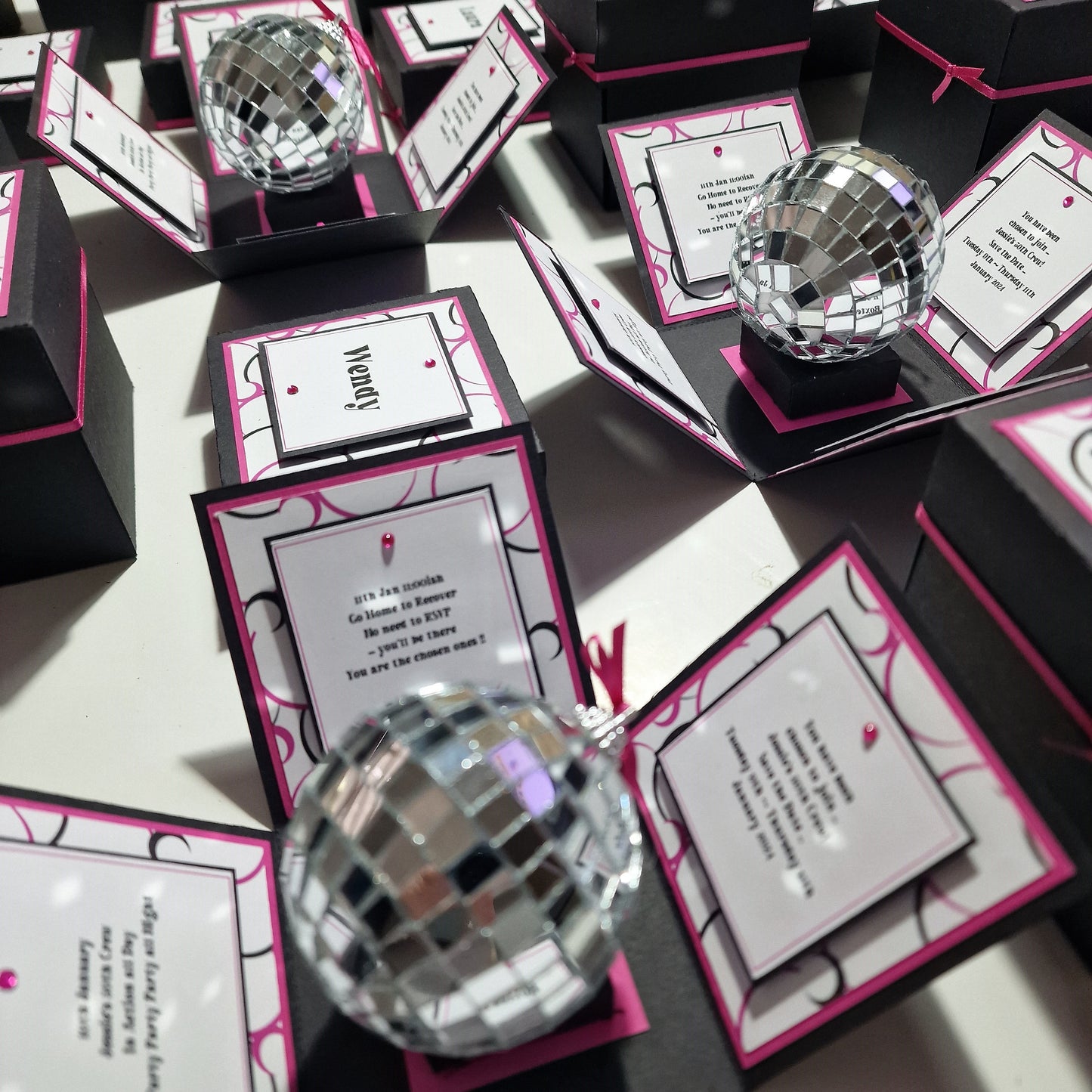 Box'd Disco Themed Invitation Boxes featuring black and pink designs with silver mirror balls, highlighting a custom-built, exploding invitation concept.