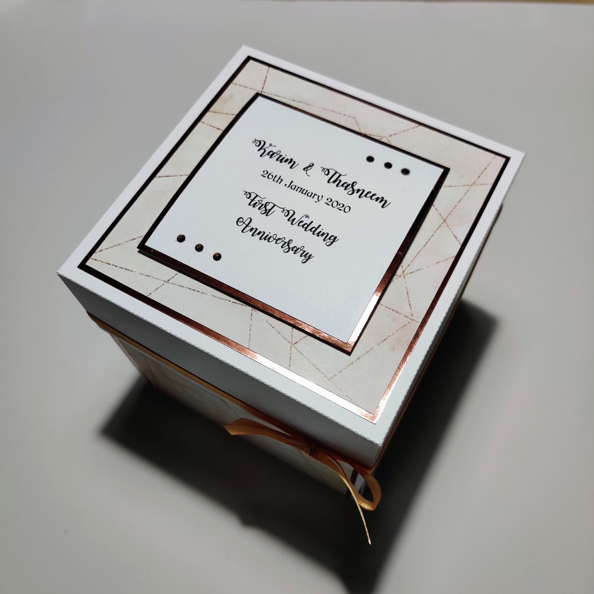 First Wedding Anniversary Exploding Box featuring a white box with gold trim, designed with coordinated colors and heartfelt messages, offering a personalized touch for a memorable keepsake.