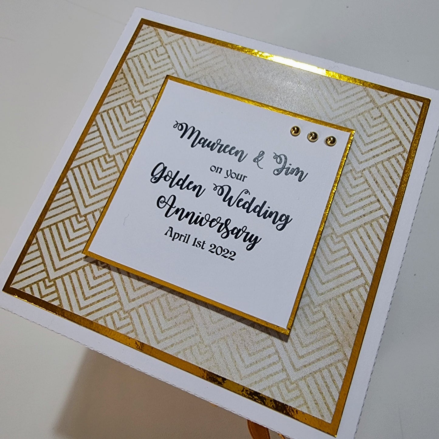 Golden Wedding Anniversary Exploding Box: A white and gold handcrafted keepsake card, featuring elegant black text and intricate designs, perfect for commemorating a 50th wedding anniversary with personalized messages and photos.