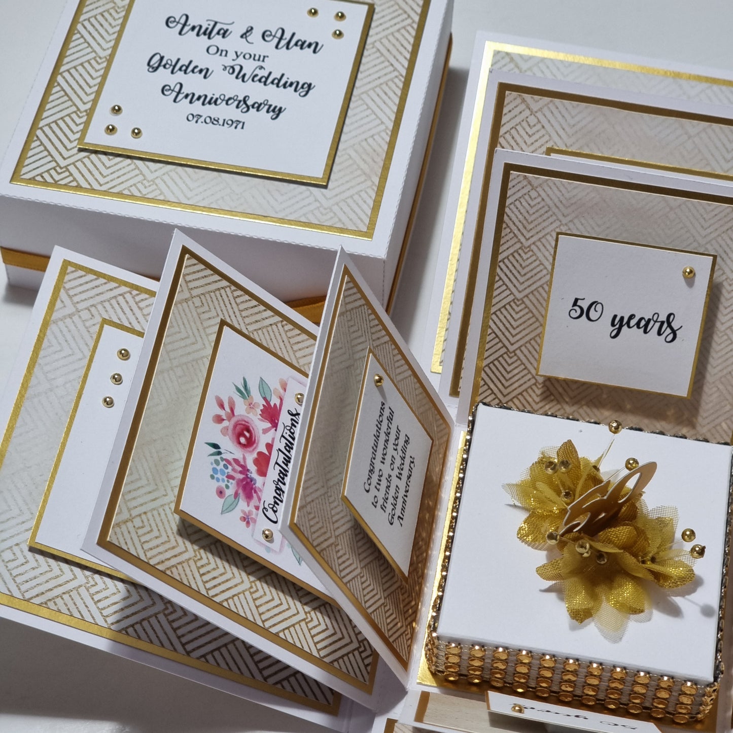 Golden Wedding Anniversary Exploding Box featuring a white base with gold floral accents, showcasing elegant craftsmanship and personalized messages celebrating 50 years of love and commitment.