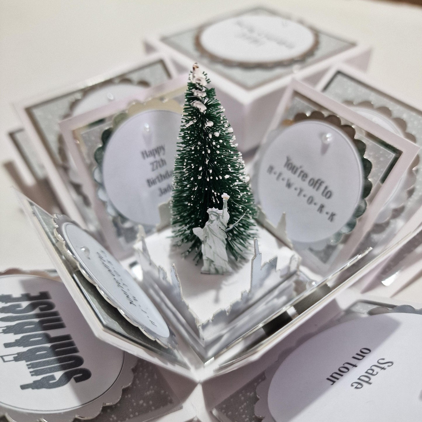 New York Christmas Trip Reveal Box featuring a Christmas tree, iconic skyline, and a miniature Statue of Liberty, designed for a personalized holiday surprise trip experience.