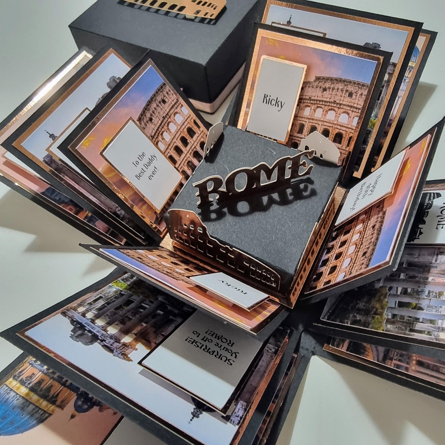 Exploding Occasions Box - Trip Reveal ROME, featuring a photo of the Colosseum, decorative panels, and space for personalized messages and trip details, designed as a surprise gift box.