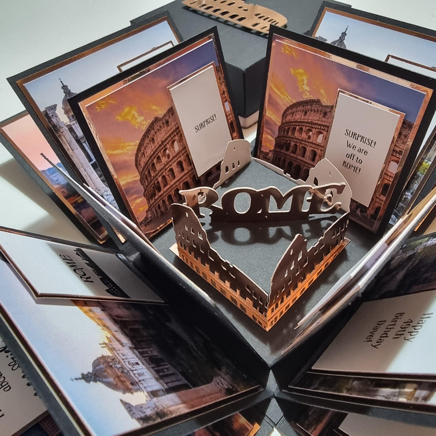 Exploding Occasions Box - Trip Reveal ROME featuring a paper box with a Colosseum image, designed for a surprise Rome trip, with intricate landscape and verse panels included.