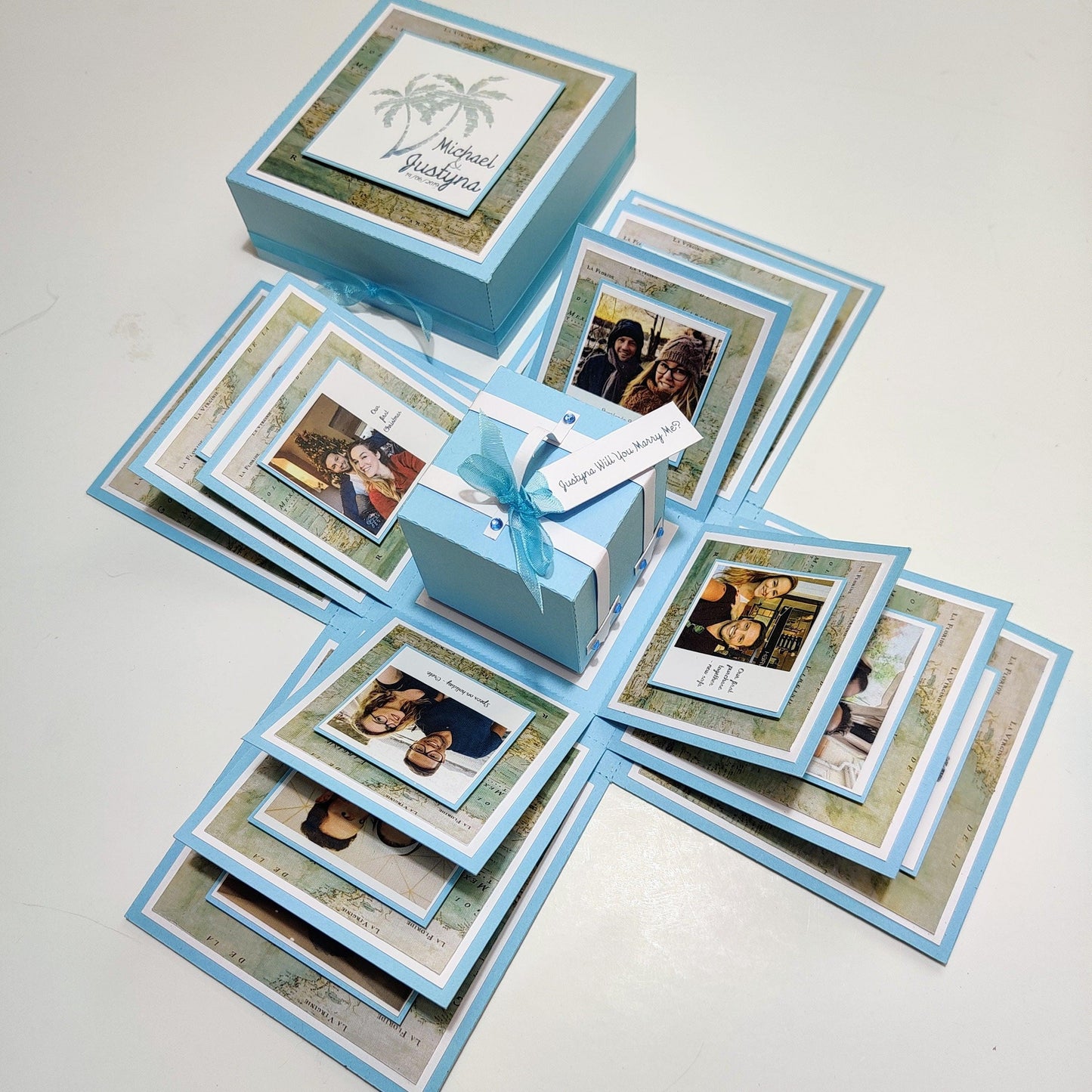 Travel Themed Proposal Box featuring an elegant blue box with a ribbon, adorned with photos and a Will you marry me? theme, perfect for memorable engagement proposals.