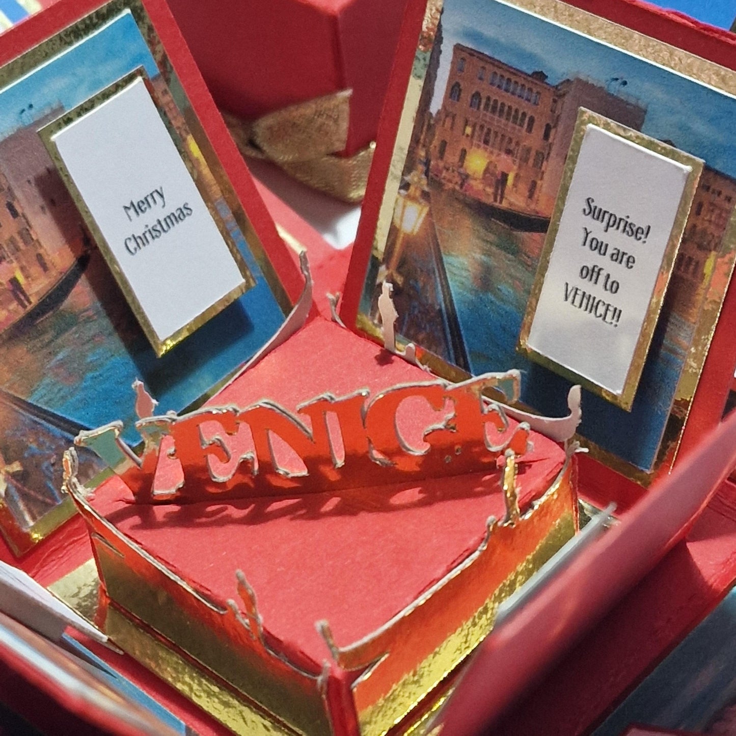 Exploding Occasions Box - Trip Reveal VENICE, showcasing a red and gold cake, cards, and Venice-themed panels, including gondola and architecture elements, perfect for surprise trip announcements.