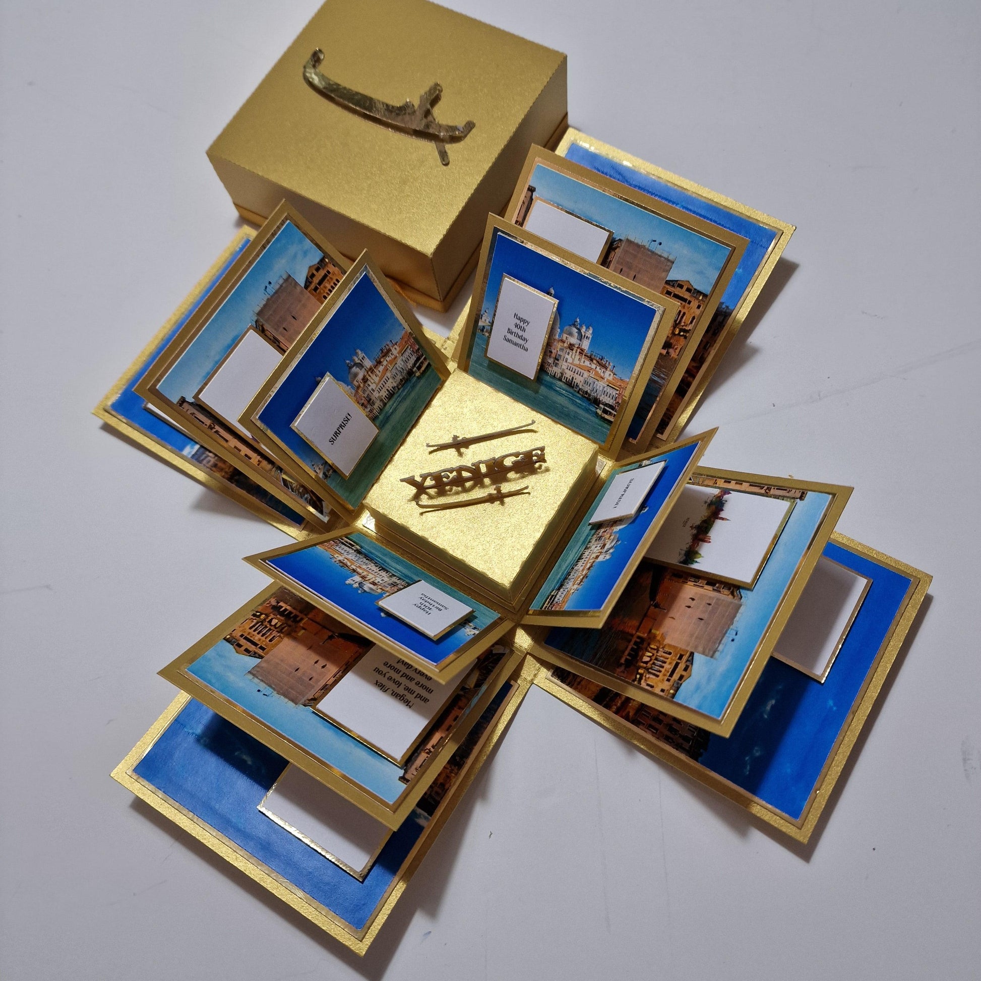 Exploding Occasions Box - Trip Reveal VENICE, featuring images of planes, ships, and Venice architecture, with paper panels and a freestanding gondola for a surprise travel announcement.